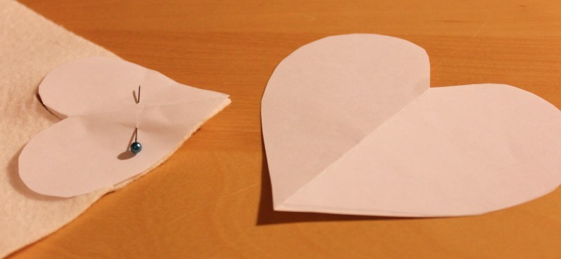Pinning down the heart pattern to cut the fabric.